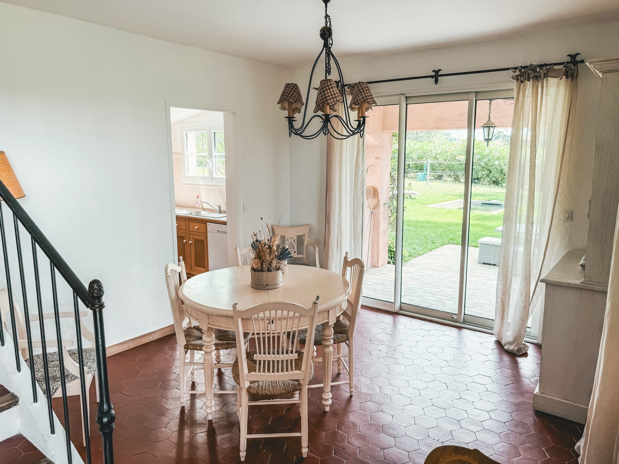 Living and dining area with terracotta floors, staircase and garden doors